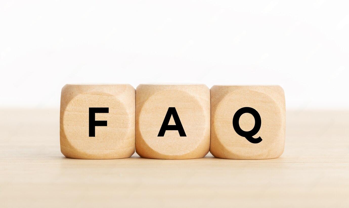 Three wooden blocks spelling FAQ on a light wooden surface.